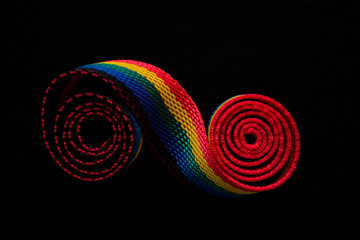 Colored tape is twisted on a dark background.
