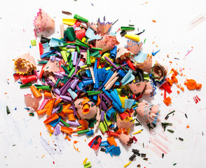 Colorful shavings obtained by sharpening colored pencils, mixed, and on the table.
