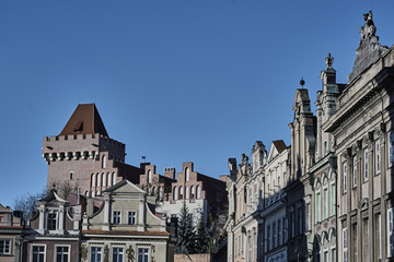 Fototapeta na wymiar Townhouses in the Old Market Square and the tower of the Royal Castle in Poznan.