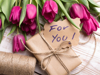 words FOR YOU and bouquet of tulips on wooden background