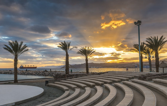 View on colorful sunset at the Red Sea; view from a stone amphitheater on central beach in Eilat - famous resort and recreational city in Israel