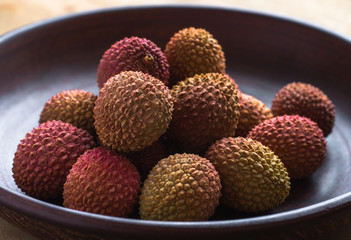 Healthy eating. Several lychee in an earthenware plate.