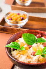 Healthy oatmeal with berries, raisins and herbs