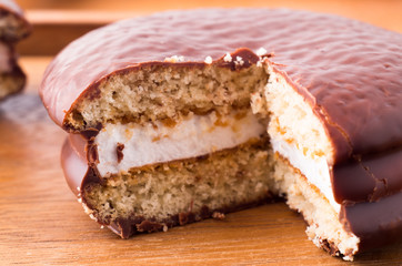 Chocolate cookies with a layer of milk souffle on a wooden table