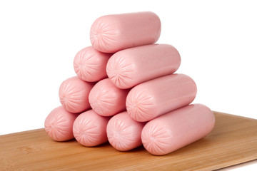 heap of sausages on a cutting board isolated  white background closeup