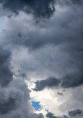 Fototapeta na wymiar Beautiful dark clouds with a tiny blue clear cloudless part