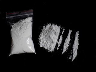 Cocaine drug powder bag, pile and lines on black background