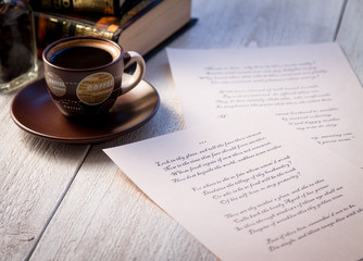 Books, coffee cup and poems on the old wooden table. Shakespeare Poems