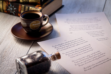 Books, coffee cup and poems on the old wooden table. Shakespeare Poems