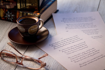 Books, coffee cup and poems on the old wooden table. Shakespeare Poems