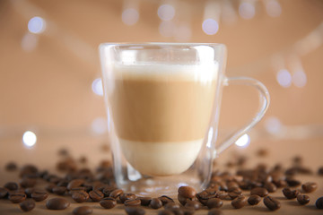 Cup of coffee with beans on lights background