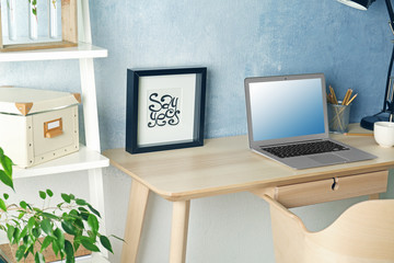 Workplace with laptop on table in modern room