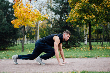 Fitness man training and jogging in fall park. Ready to start. Healthy lifestyle