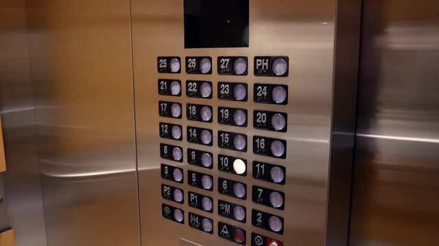 Woman scanning key tag and pressing a button the ten floor in an elevator