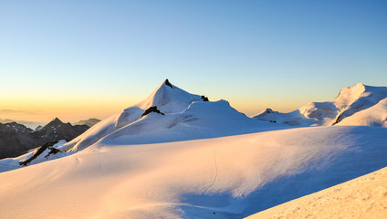 Stunning sunrise at 3800m amsl in the Swiss Wallis Alps near the summit of Alphubel (4206m). Allalinhorn, Strahlhorn & Rimpfischhorn in the background (left to right). Snow fields in foreground.