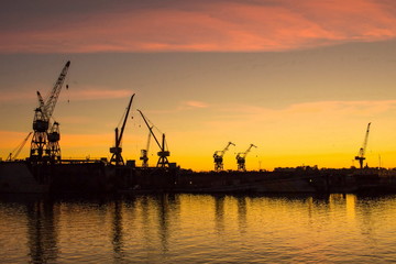 Fototapeta na wymiar Cranes at sunset in port of Riga