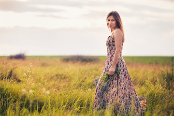 Obraz premium Girl with wild flowers in their hands