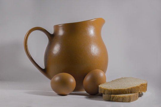 jug with chicken eggs and sliced bread