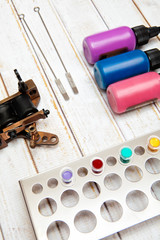 Tattoo machines and three bottles of ink isolated on white background. Tattoo guns.