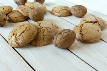 Macaroons cookies  and walnut on the white wooden background
