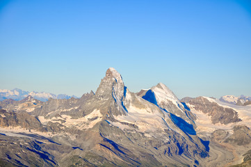 Fototapeta premium Stunning sunrise view of Matterhorn (4478m) and Dent D'Herens (4174m) in the Swiss Wallis Alps seen from the summit of Alphubel (4206m). Climate change causes the glaciers around to shrink.