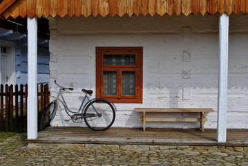 Rower przed drewnianym domem