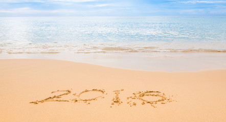 Drawing Year 2016 in sand on the beach