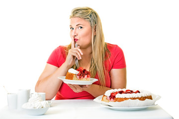 Guilty fat woman eating a slice of cream cake.