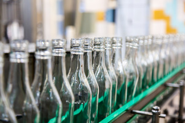 The bottles on the conveyor belt at the plant for bottling of al