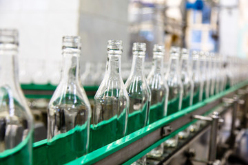 The bottles on the conveyor belt at the plant for bottling of al