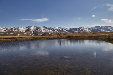 Mountainbiker girl near mountain lake