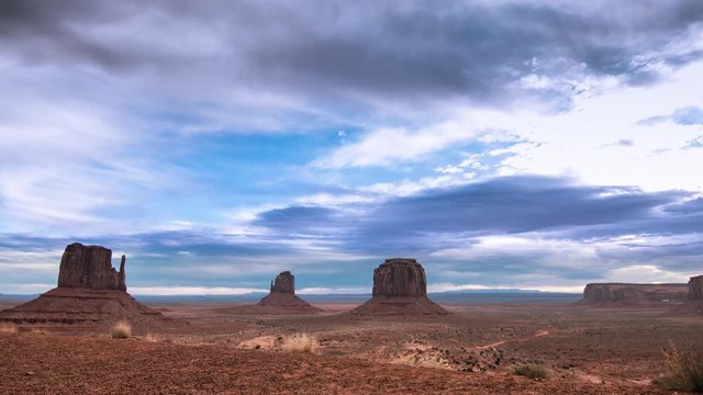 Time lapse clouds travel over Monument Valley National Monument as night falls.