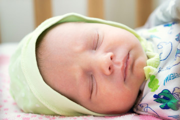 Cute newborn baby sleeps in the bed. Stock photo