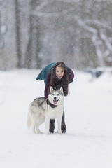 Caucasian Brunette Girl Posing With Her Husky Dog Outside in Winter Forest