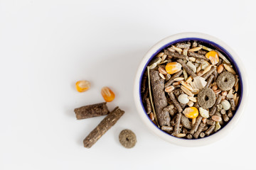 dry food for rodents in bowl white background top view