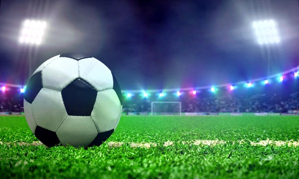 Soccer ball in a stadium field with bright spotlights