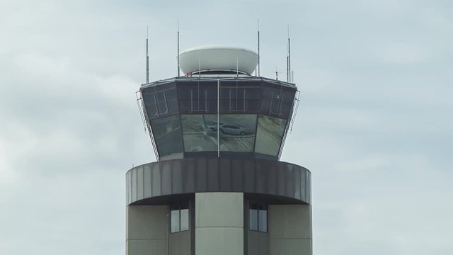 Close-up of the Air Traffic Control ATC Tower at Louis Armstrong New Orleans International Airport with Communication Antennae and Spinning Radar on a Cloudy Overcast Day in Louisiana