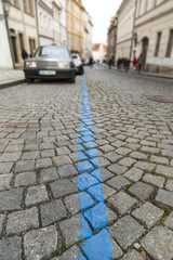 Blue parking lane on old cobblestone pavement