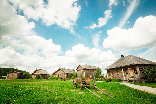 Summer rural landscape with a cart and huts