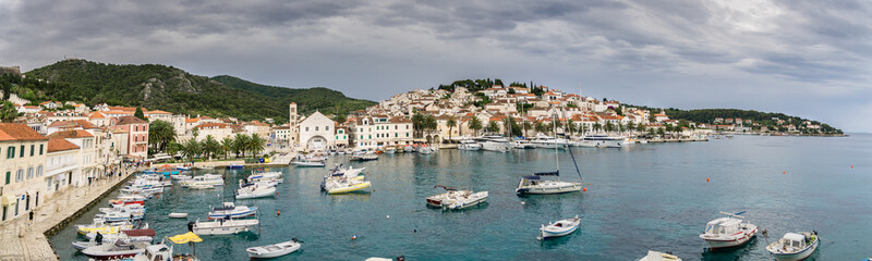 Fototapeta na wymiar A panoramic image of the port of Hvar Town, Croatia, in summer with a storm approaching over the old town.