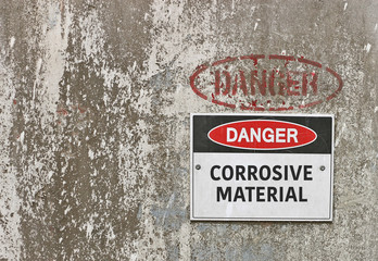 red, black and white Danger, Corrosive Material warning sign