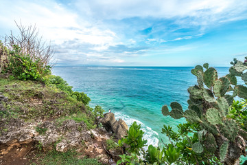 Tropical island landscape, ocean on a bacakground. Beautiful view from the cliff to the coast. Outdoor scenery, Bali island, Indonesia.