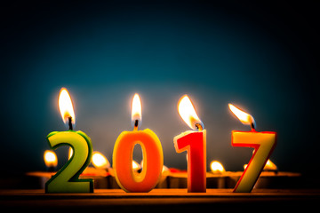 Happy new year 2017. Frame and candles  numbers on wood table.
