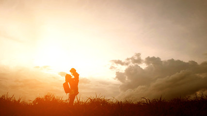 Silhouette of A mother and son playing outdoors at sunset.
