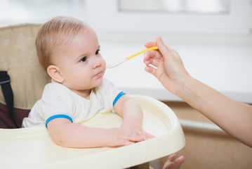 mother feeding her baby breast porridge day