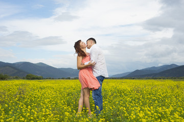 Lovers man and woman walk on the flower field.