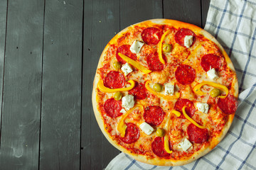 Fresh tasty pizza on wooden background