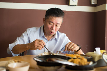 Fototapeta na wymiar asian matured male eating bah kut teh