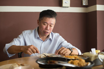 asian matured male eating bah kut teh