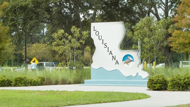 Louisiana Welcome Center on Interstate 10 Medium Shot with People Walking in the Backgrounds featuring Signage, Green Grass and Trees on a Sunny Day